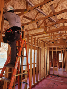 An electrician installing wiring in new construction at a job site for Colonial Electric LLC in Scottsdale, AZ.