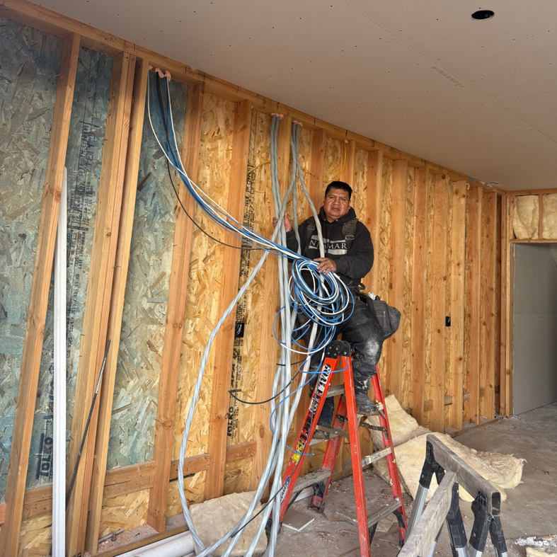 An electrician installing new electrical wiring in a residential construction project for Goal Electric LLC in West Valley City, UT.