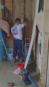 An electrician installing new wiring and electrical boxes in a wall during a construction project by Delta Electric in Germantown, MD.