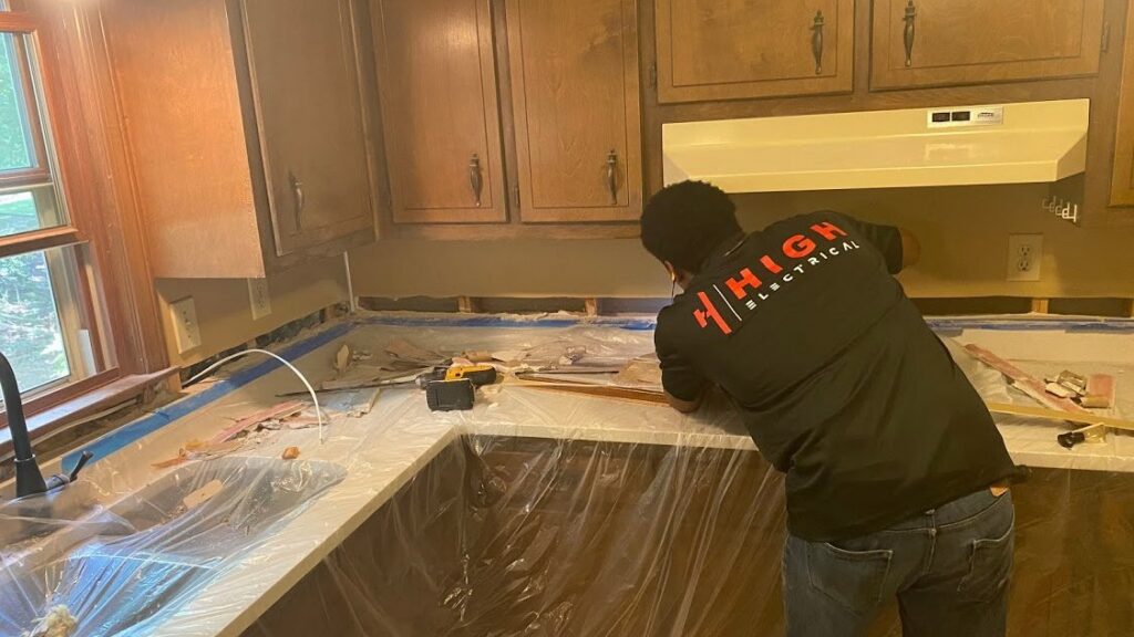 An electrician from High Electrical performing wiring installation in a kitchen in Atlanta, GA.