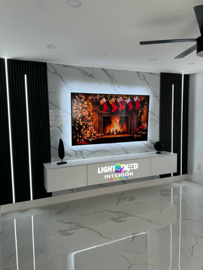Lightsoled electricians installing modern LED strip lighting and a wall-mounted TV in a Miami, FL living room.