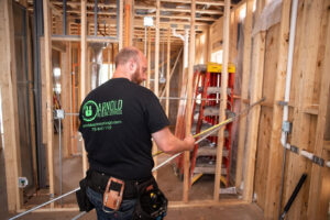 An electrician from Arnold Electrical Repair & Installation measuring conduit for new wiring in a residential construction project in Chicago, IL.