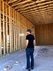 An electrician from Reuben Electrical Contracting inspecting electrical rough-in work on a construction site in Scottsdale, AZ.