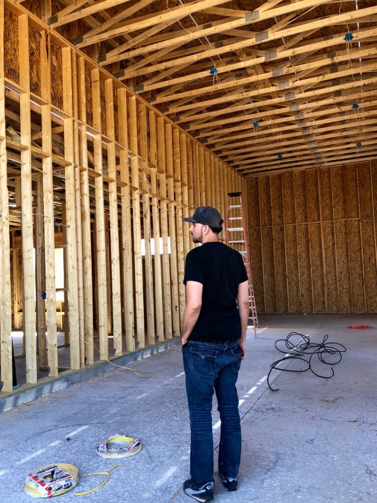 An electrician from Reuben Electrical Contracting inspecting electrical rough-in work on a construction site in Scottsdale, AZ.