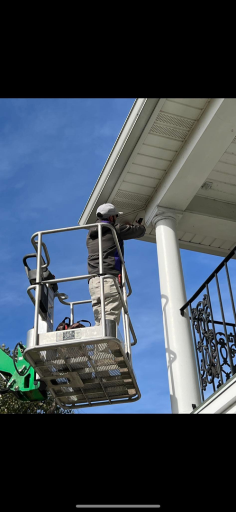 An electrician from Bonafide Electrical Services on a lift installing exterior lighting in Denham Springs, LA.