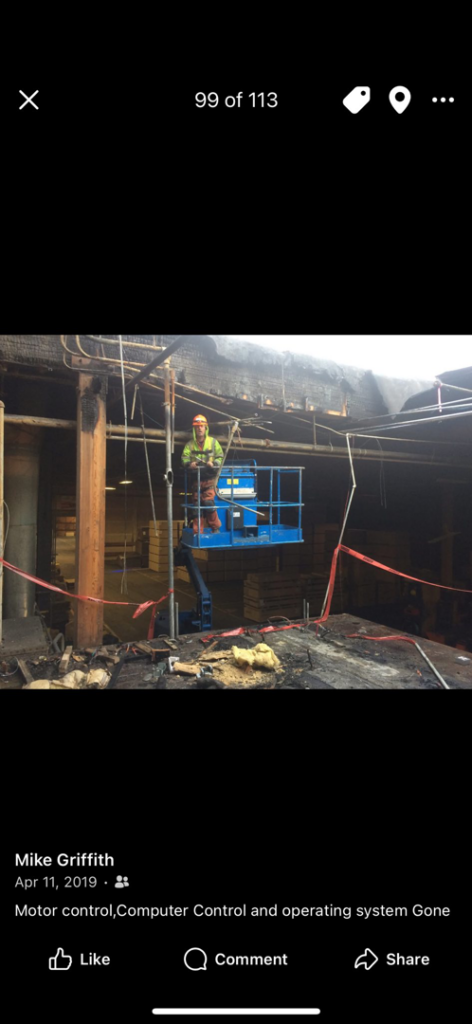 An electrician from GM Electric Inc. on a lift repairing overhead wiring in a damaged industrial building in Kalispell, MT.