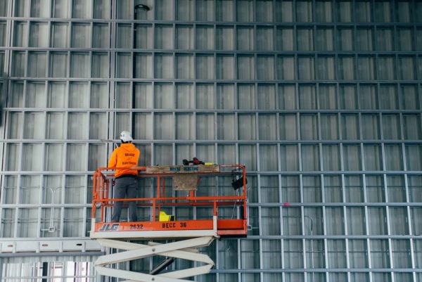 An electrician on a scissor lift performing commercial wiring installation for Brase Electrical Contracting Corp in Omaha, NE.