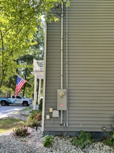 An electrician from Surge Electric LLC on a scissor lift, performing outdoor lighting or utility pole work in Youngstown, OH.