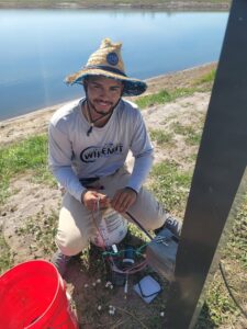 An electrician performing outdoor wiring installation near a body of water for Wirenut Technologies LLC in Brandon, FL.