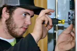 A young electrician performing detailed electrical work with a screwdriver on a panel for Rebco Electric in Lebanon, OH.