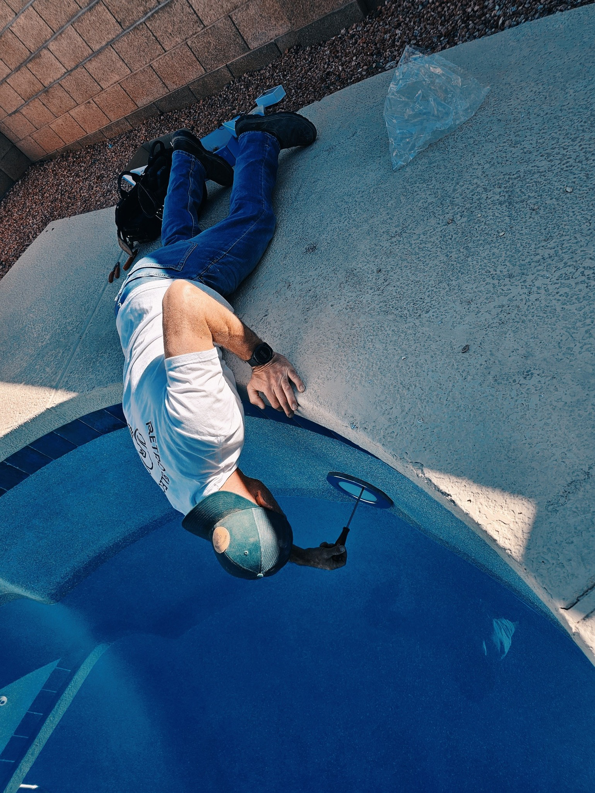 An electrician from Retro Electric AZ performing electrical work on a residential swimming pool in Higley, AZ.