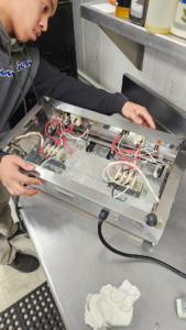 An electrician from Spruce Electrical inc. repairing complex appliance wiring in High Point, NC