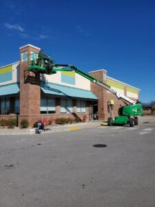 An electrician in a lift repairing commercial exterior lighting or signage at Discount Electrical Service of Franklin in Franklin, TN