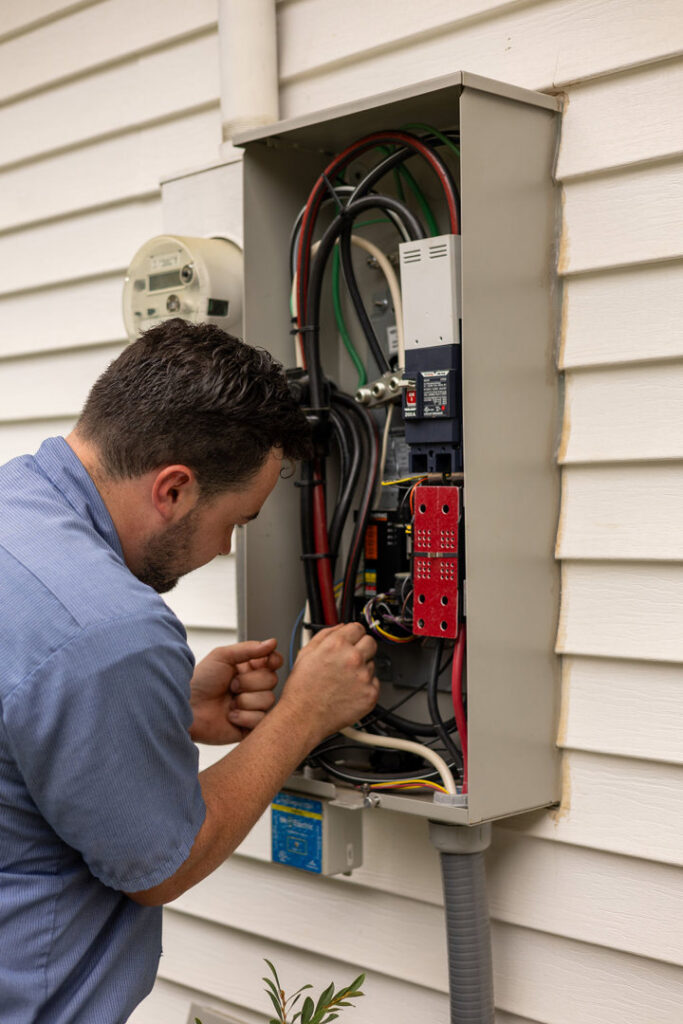 An electrician repairing an outdoor electrical box and wiring for Mr. Electric of Montgomery County Alabama in Montgomery, AL.