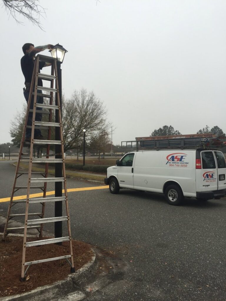 An electrician from All Service Electric repairing an outdoor light fixture in Jacksonville, FL.