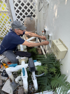 An electrician repairing outdoor pool electrical wiring and controls for Electric Service & Repair, Inc in Miami, FL.