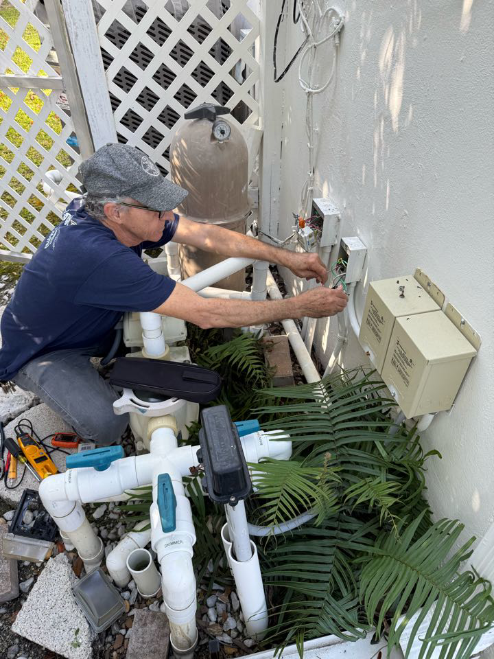 An electrician repairing outdoor pool electrical wiring and controls for Electric Service & Repair, Inc in Miami, FL.