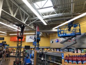 An electrician from Valley Electric Inc in Lewiston, ID, repairing sign lighting from a bucket truck.