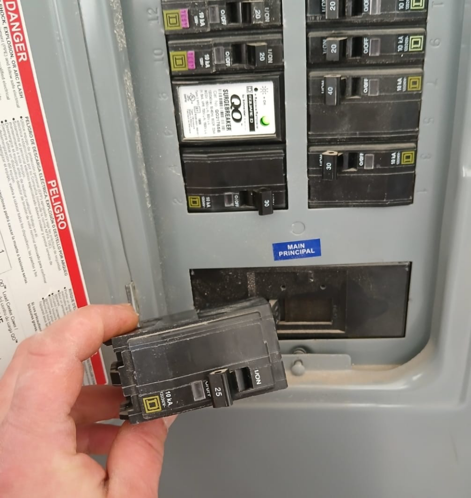 An electrician from Jesano Electric in Fort Worth, TX, replacing a circuit breaker in an electrical panel.