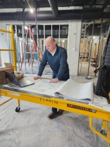 An electrician from Flavin Electric, LLC reviewing blueprints on a construction site in Chicago, IL