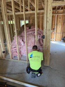 An electrician from Weiss Electric LLC performing rough-in wiring during new construction in Saint Charles, MO.