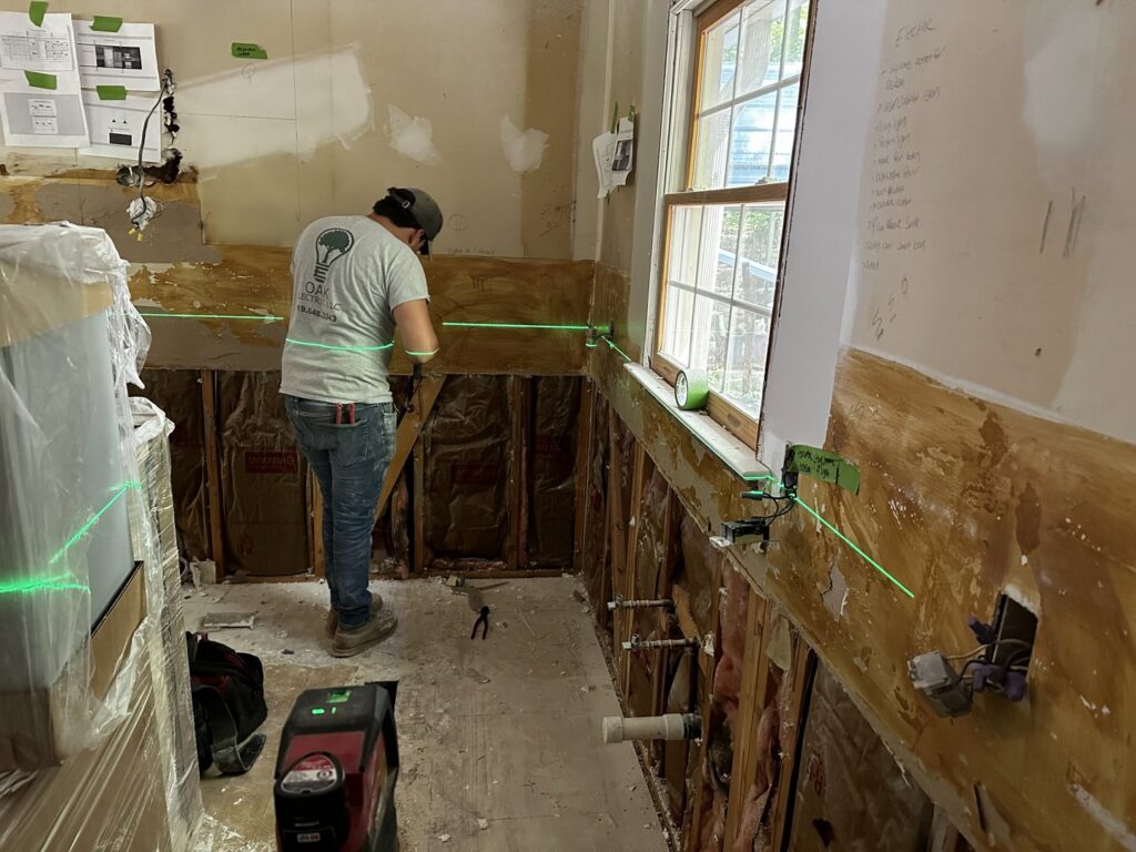 An electrician performing rough-in wiring during a home renovation for Oak Electric LLC in Waterford, MI.