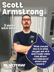 Electrician Scott Armstrong standing in front of electrical panels and conduits at Votaw Electric in Fort Wayne, IN