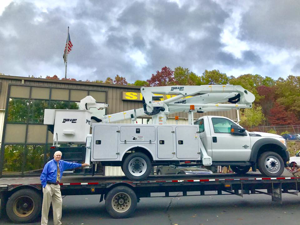 An electrician's service truck with a boom lift, ready for commercial lighting jobs by Lighting Services, Inc. in Waterbury, CT.