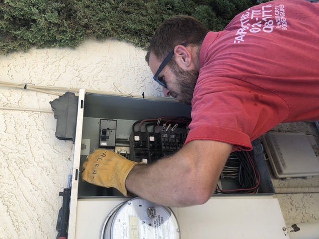 An electrician from Farris Electric LLC servicing a residential breaker panel in Glendale, AZ.