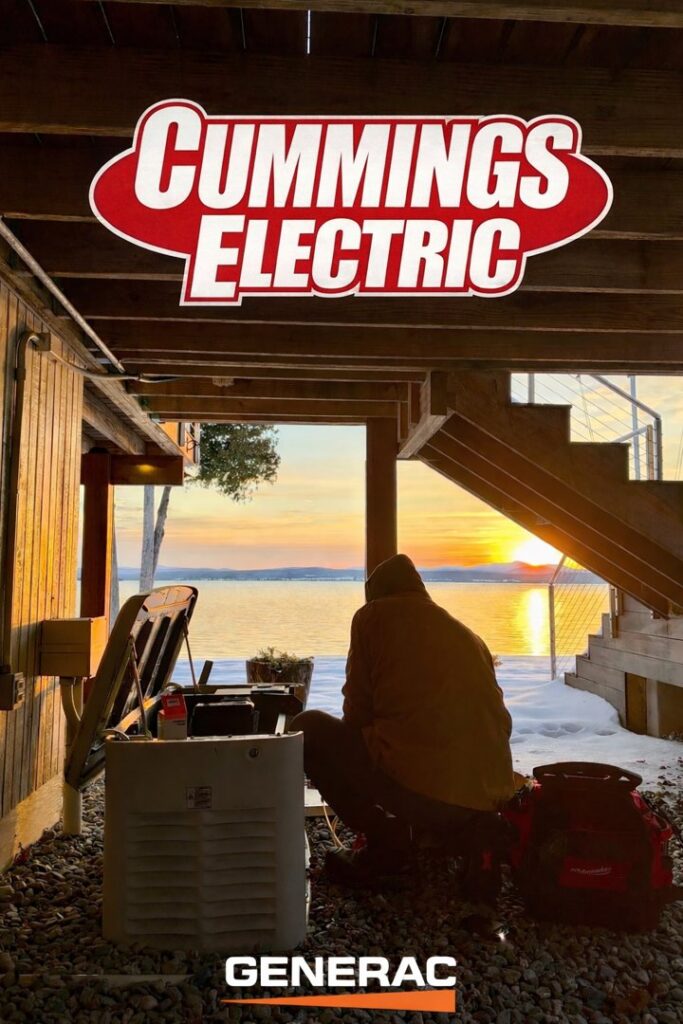 An electrician from Cummings Electric servicing a Generac standby generator outdoors in South Burlington, VT