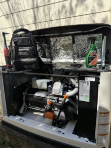 An electrician servicing a Generac standby generator with tools at a client's home by Gen Central Power Systems in Houston, TX