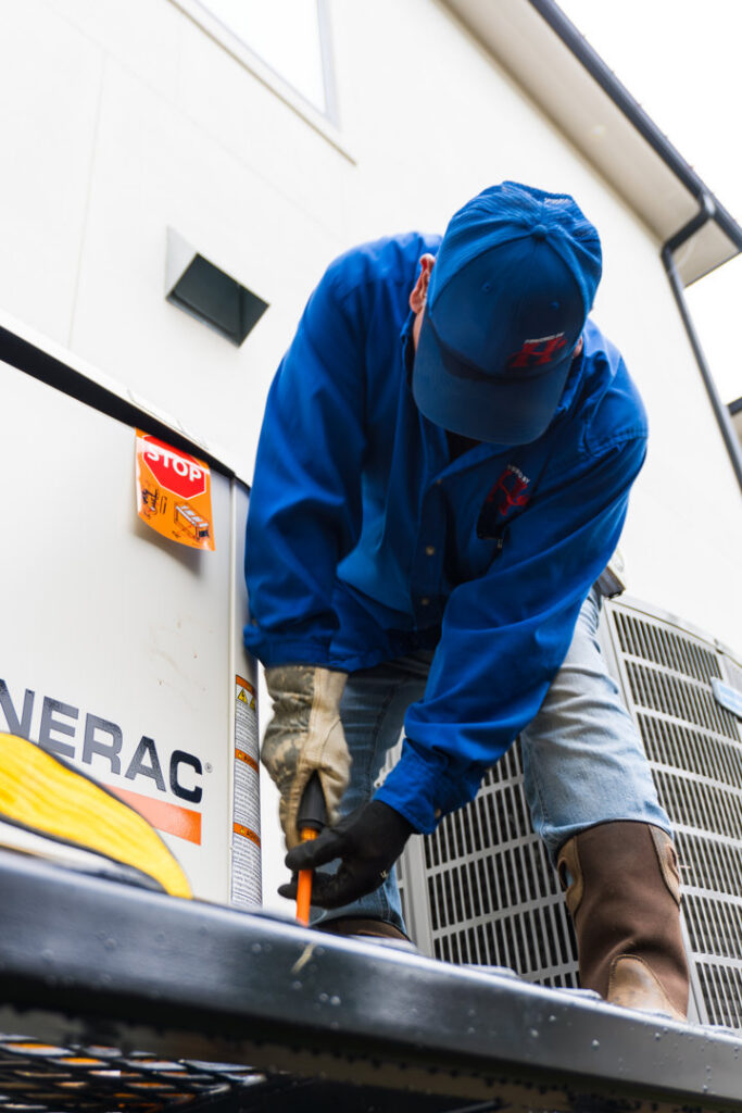 An electrician from Powered By H servicing a Generac standby generator in Houston, TX.