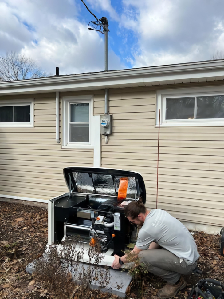 An electrician from RJ Boyd Electric servicing a Generac whole-house generator at a residence in Christiansburg, VA.
