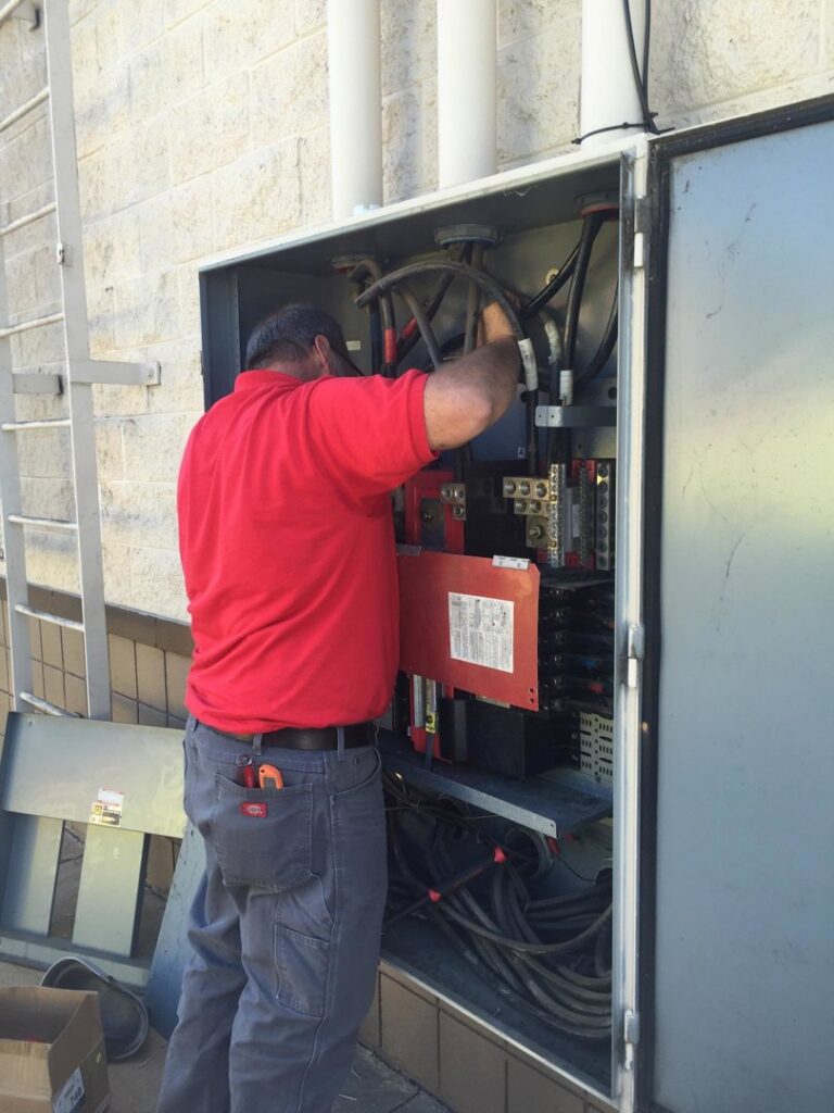 An electrician servicing a large outdoor electrical panel for Mr. Electric of Montgomery County Alabama in Montgomery, AL.