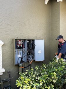 An electrician from Bee Electrical Contracting servicing an outdoor electrical panel in Port Saint Lucie, FL.