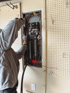 An electrician from Tier 1 Electric servicing a residential electrical panel in Boise, ID