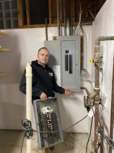 An electrician from Diaz Techician LLC in Chicago, IL, showcasing a new electrical panel installation after an upgrade.