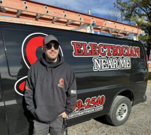 An electrician standing proudly by a branded work van for Electrician Near Me in Broken Arrow, OK.