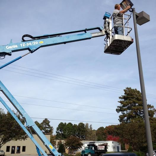 An electrician in a lift bucket performing street light repair for Wire That Up-Fire Suppression & Hood Electrical in Suffolk, VA.