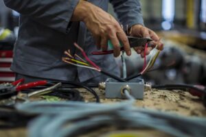 Electrician's hands stripping and connecting electrical wires for Omni Power Electrical Services LLC in San Antonio, TX