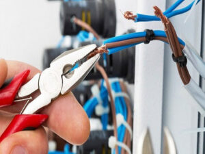 A close-up of an electrician's hands using pliers to strip an electrical wire, demonstrating precision work by Legacy Electric in Westminster, CO.