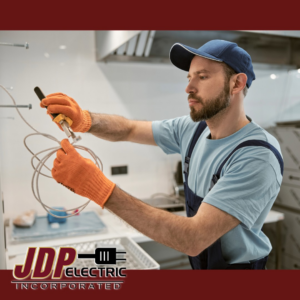 An electrician wearing gloves stripping electrical wires during a job for JDP Electric in Fargo, ND.