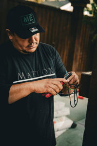 An electrician from Mattox Electric, LLC in Dallas, TX, carefully stripping electrical wires with a specialized tool.
