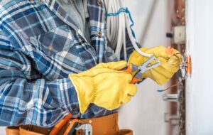 An electrician stripping wires for an outlet installation, demonstrating work by Next Level Contracting LLC in Dayton, OH