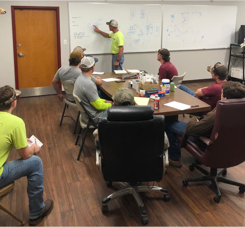 Albritton Electrical Service, Inc. team members in a meeting, discussing electrical diagrams in Tallahassee, FL.
