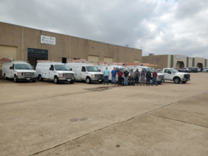 The AccuTex Electric team standing proudly with their service vans and trucks in Fort Worth, TX.