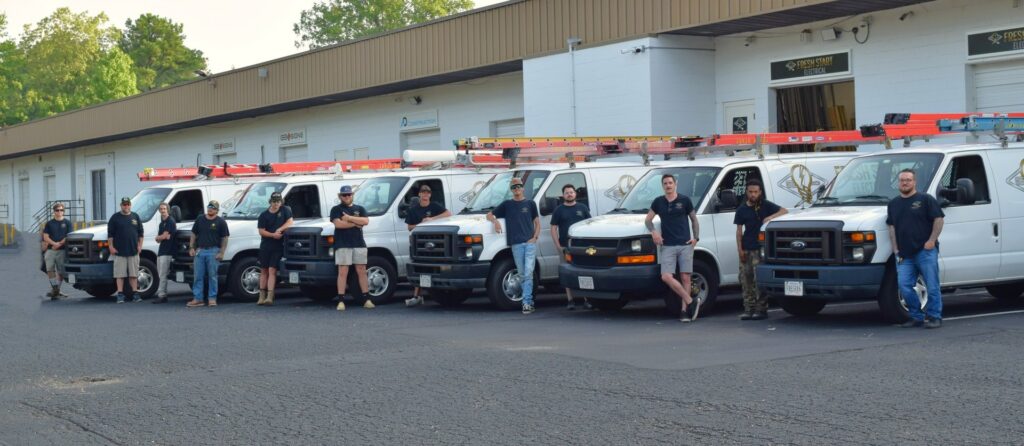 The Fresh Start Electrical, LLC team standing with their work vans in Newport News, VA