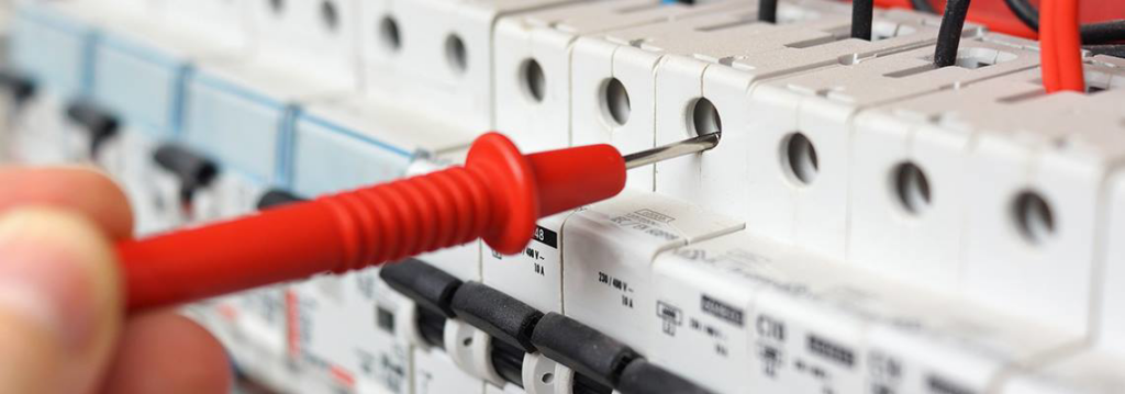 An electrician testing a circuit breaker panel with a voltage tester for Gerard A LaFlamme Inc in Londonderry, NH.