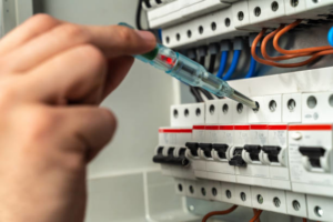 An electrician testing a circuit breaker panel with a voltage tester at Andrews Electric Services in Knoxville, TN