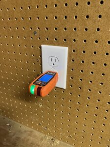 An electrician from Circuit Masters, Inc. testing an electrical outlet with a tester in Billings, MT.
